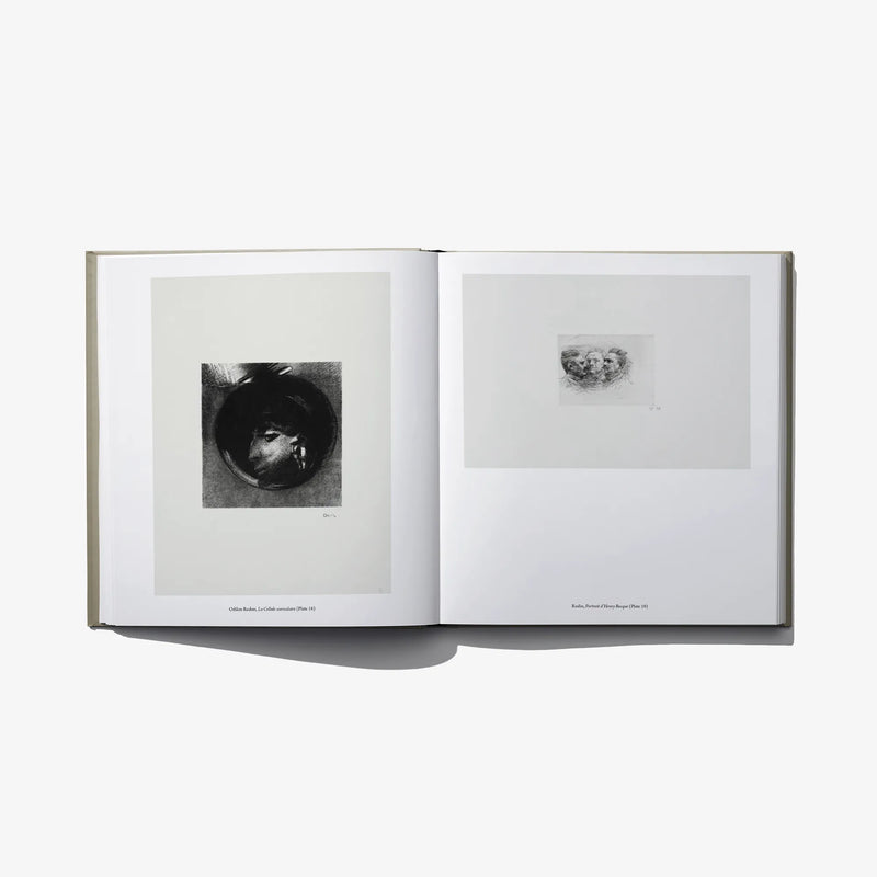 Open hardcover book with monochrome eye print on left and small sketch on right