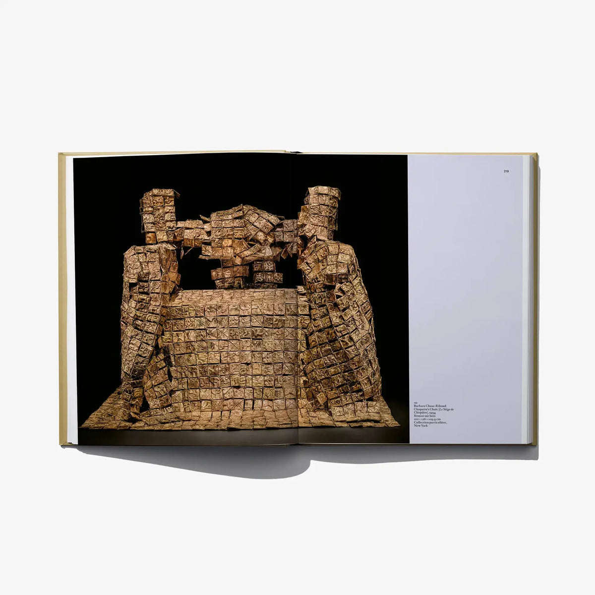 Open art book page showing ancient carved stone relief tablets
