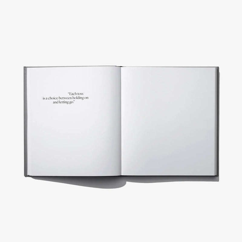 Open photo book with two blank pages and a small quote printed near center