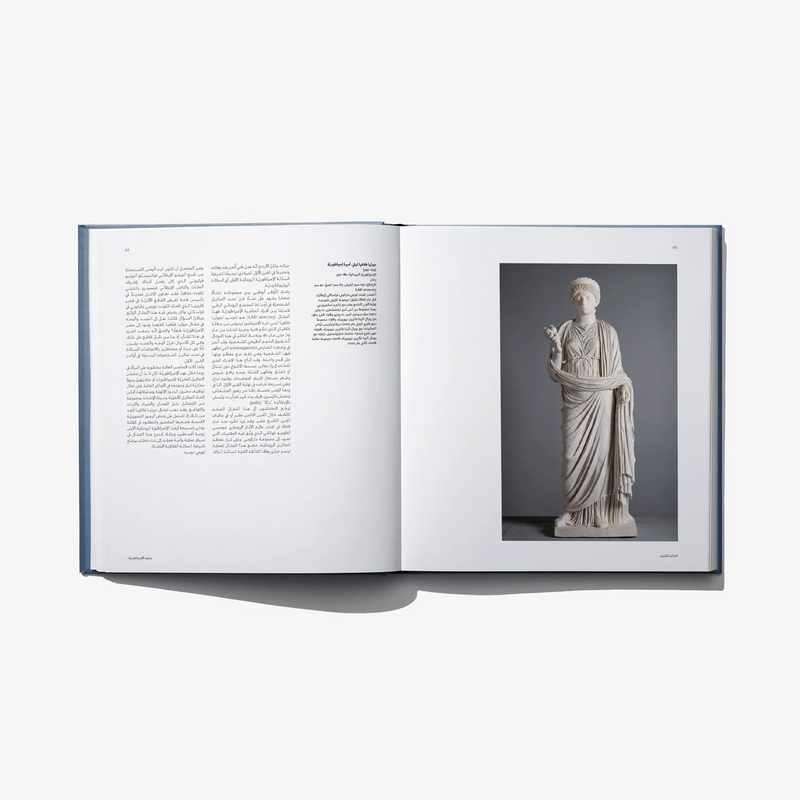 Open art book spread with a marble statue photo and Arabic text on the left page
