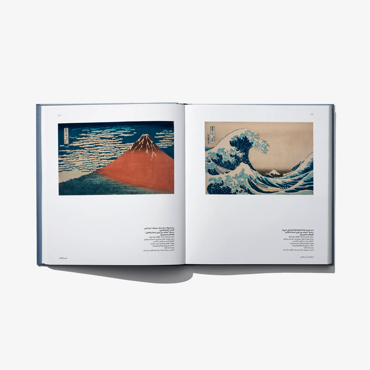 Open art book spread with two landscape artworks and Arabic text beneath each image