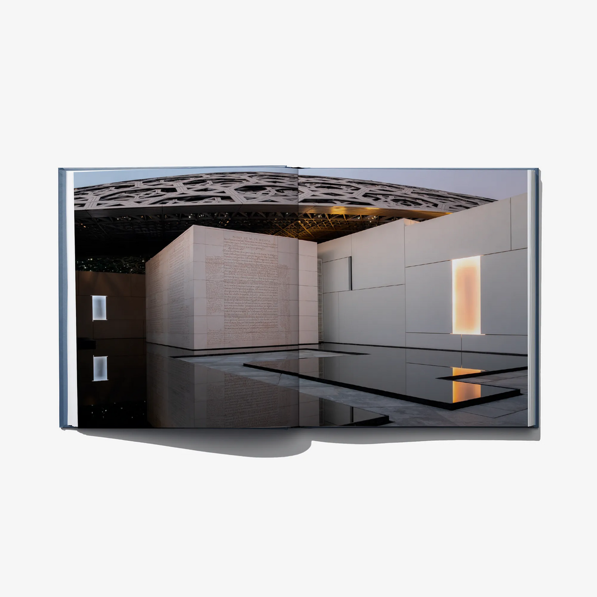 Open art book featuring a museum interior photo with display walls and skylight