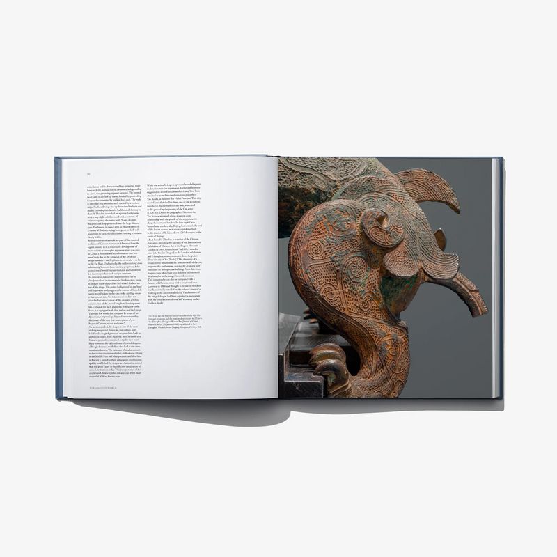 Open art book spread with a detailed bronze animal sculpture on right page