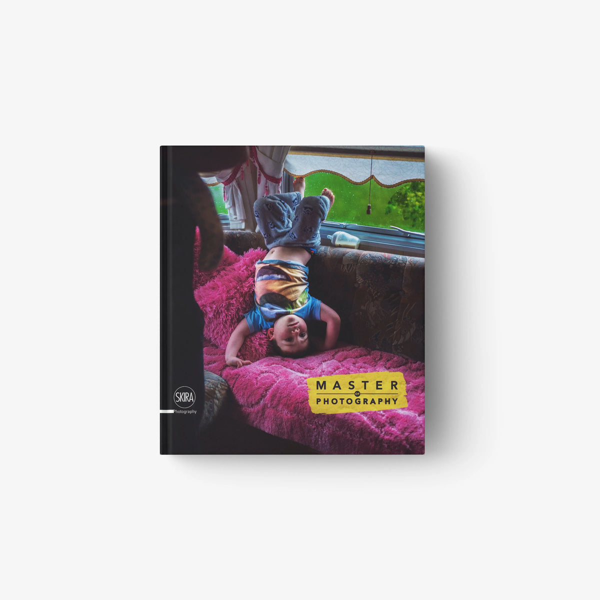 Photographic book by Skira Arte with hardback cover, featuring a child on a pink rug in a brightly lit room