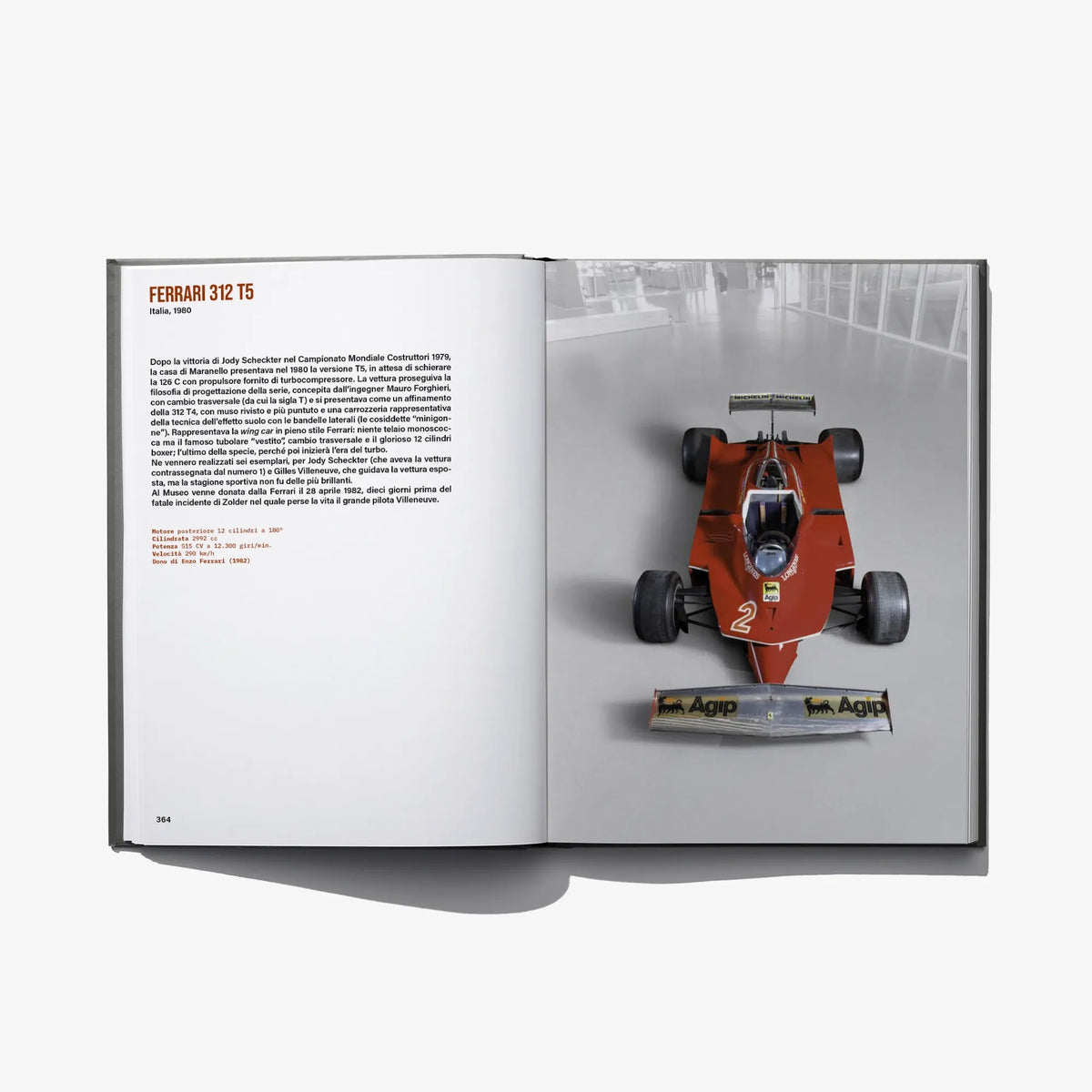 Open book spread showing an orange race car model on the right page