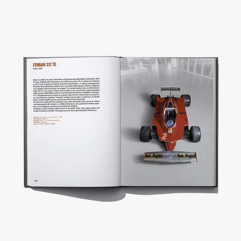 Open book spread showing an orange race car model on the right page