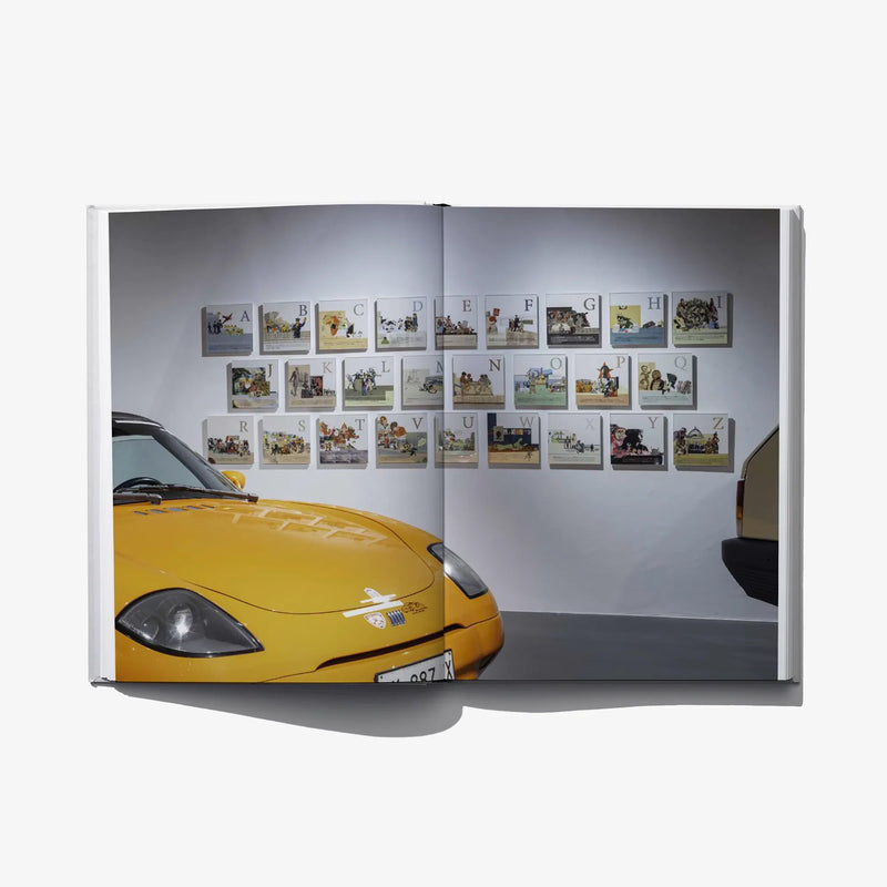 Convergences open spread with wall display of small artwork prints and letter labels