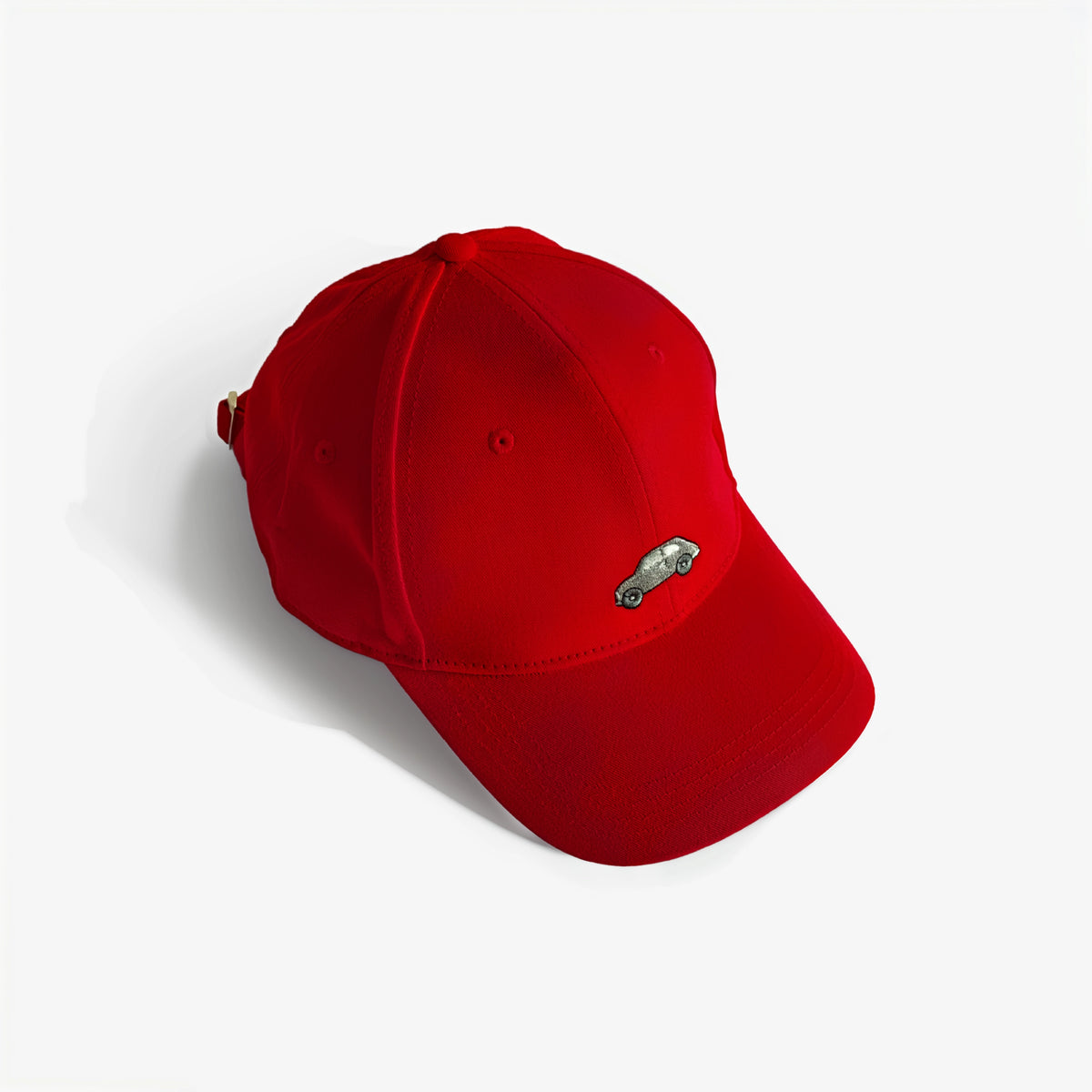 Red baseball cap with small embroidered car logo patch
