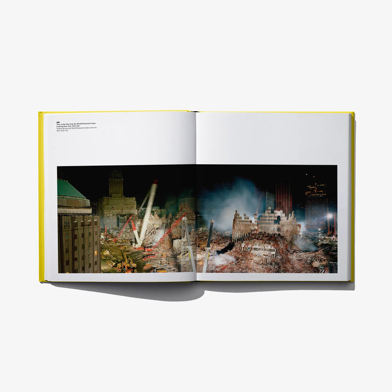 Open photo book spread with a nighttime city scene photo across both pages.