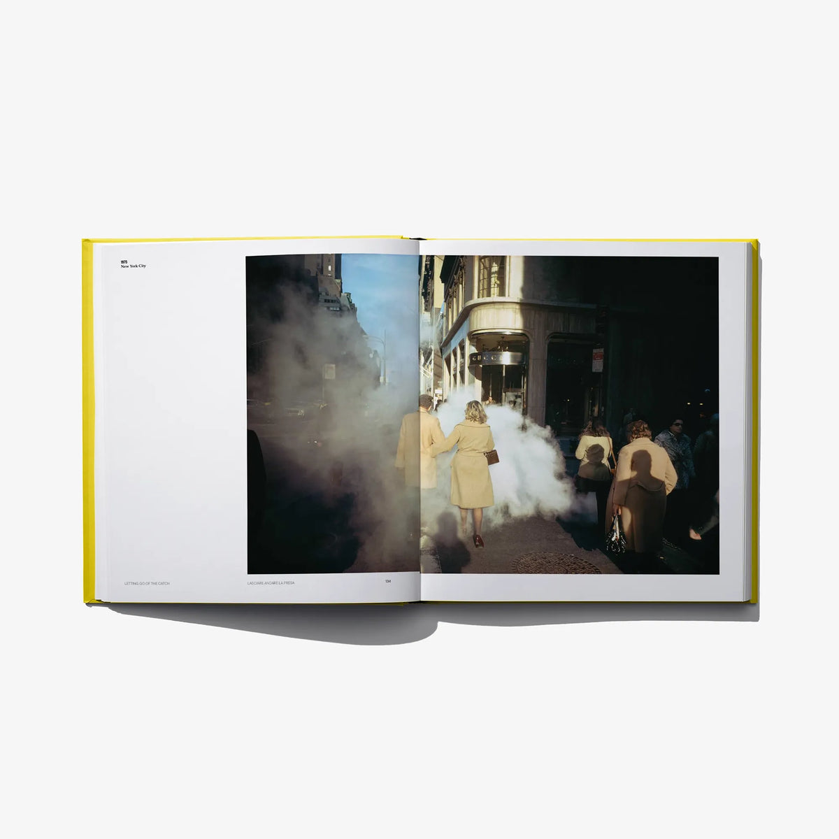 Open photo book spread with a street scene photo featuring people in the right page.