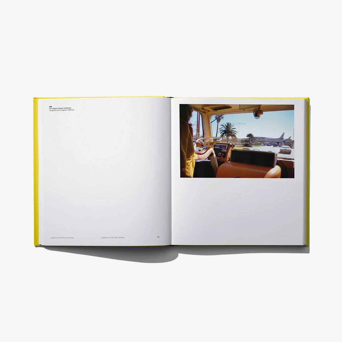 Open photo book spread with an interior car photo featuring a seated person on right.