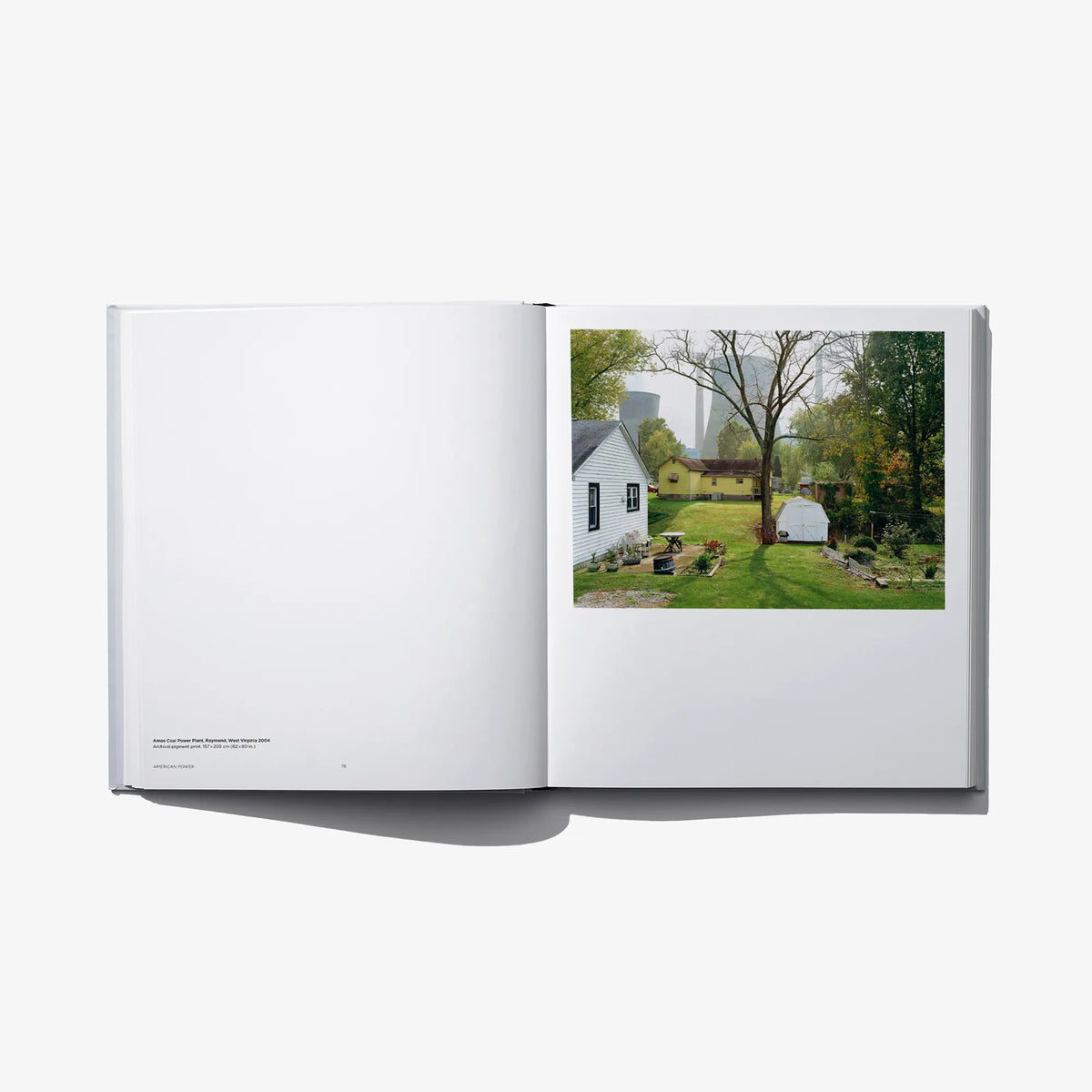 Open hardcover photo book with yard and house photo on the right page