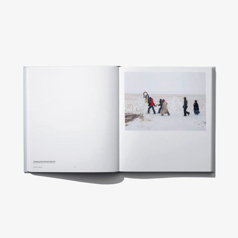 Open hardcover photo book with snowy hikers photo on the right page