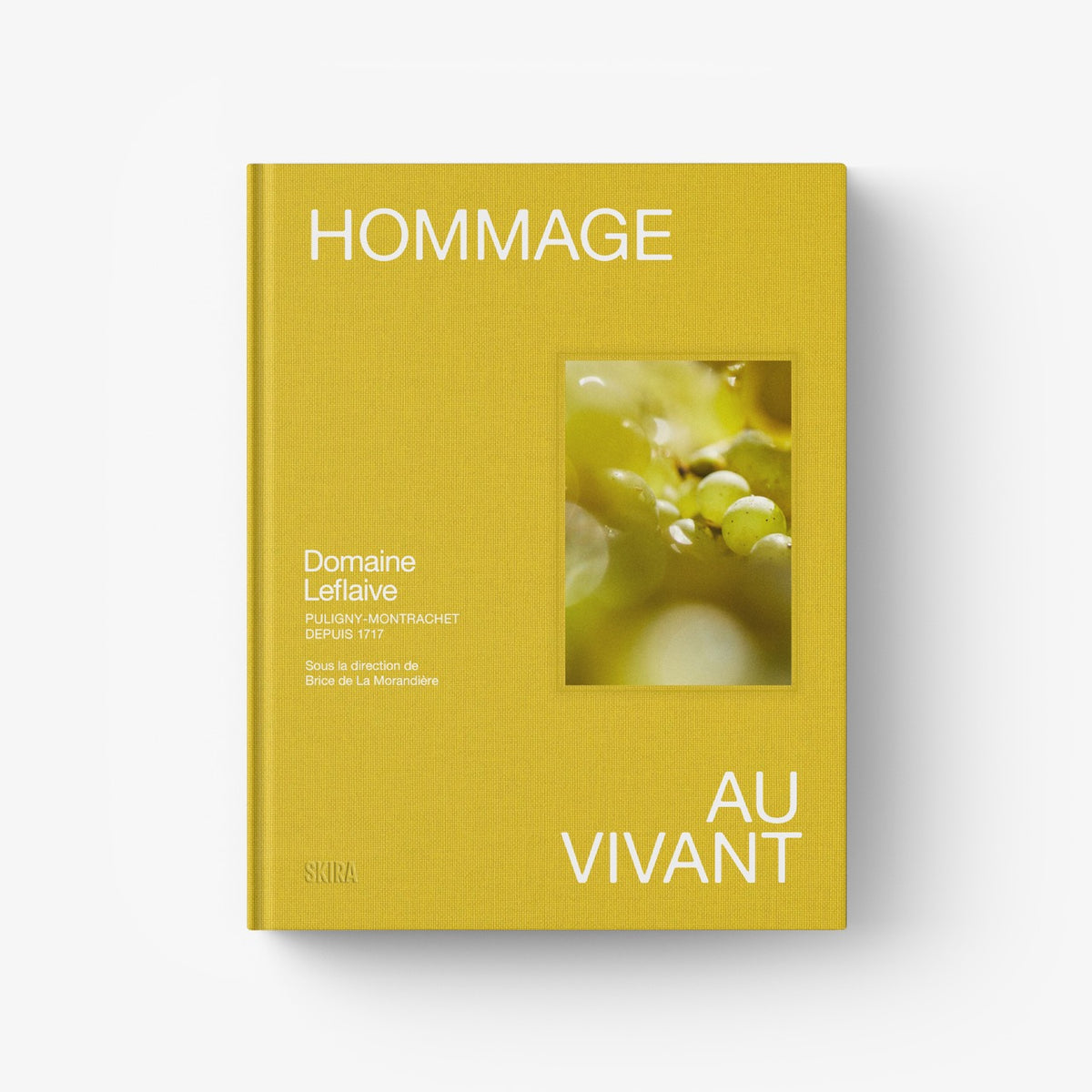 Yellow hardcover book with “HOMMAGE AU VIVANT” title and Domaine Leflaive photo window