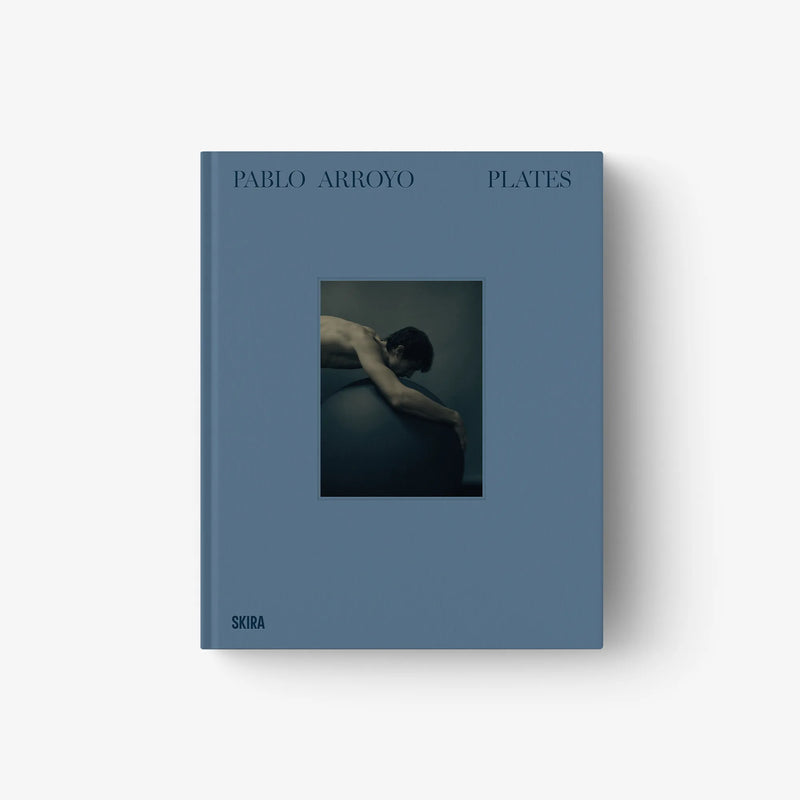 Art book with blue cover, 'PABLO ARROYO' and 'PLATES' titles, framed photo on front.