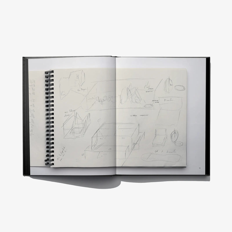 Open sketchbook page with spiral binding and multiple pencil design sketches