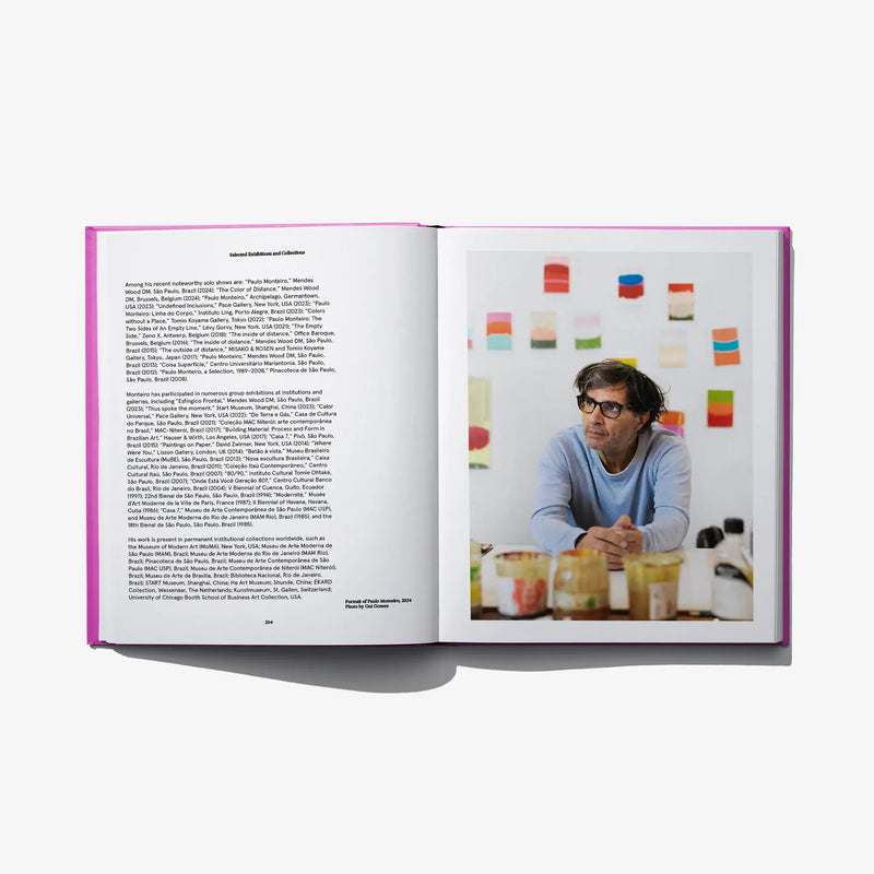 Open art book with studio photo on right showing an artist at work