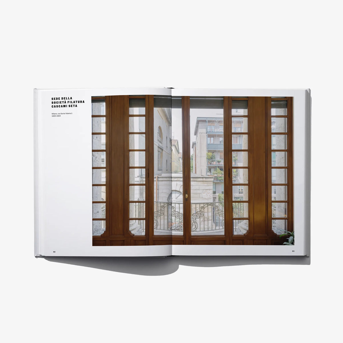 Open hardcover book with large window-and-door interior photo across both pages.