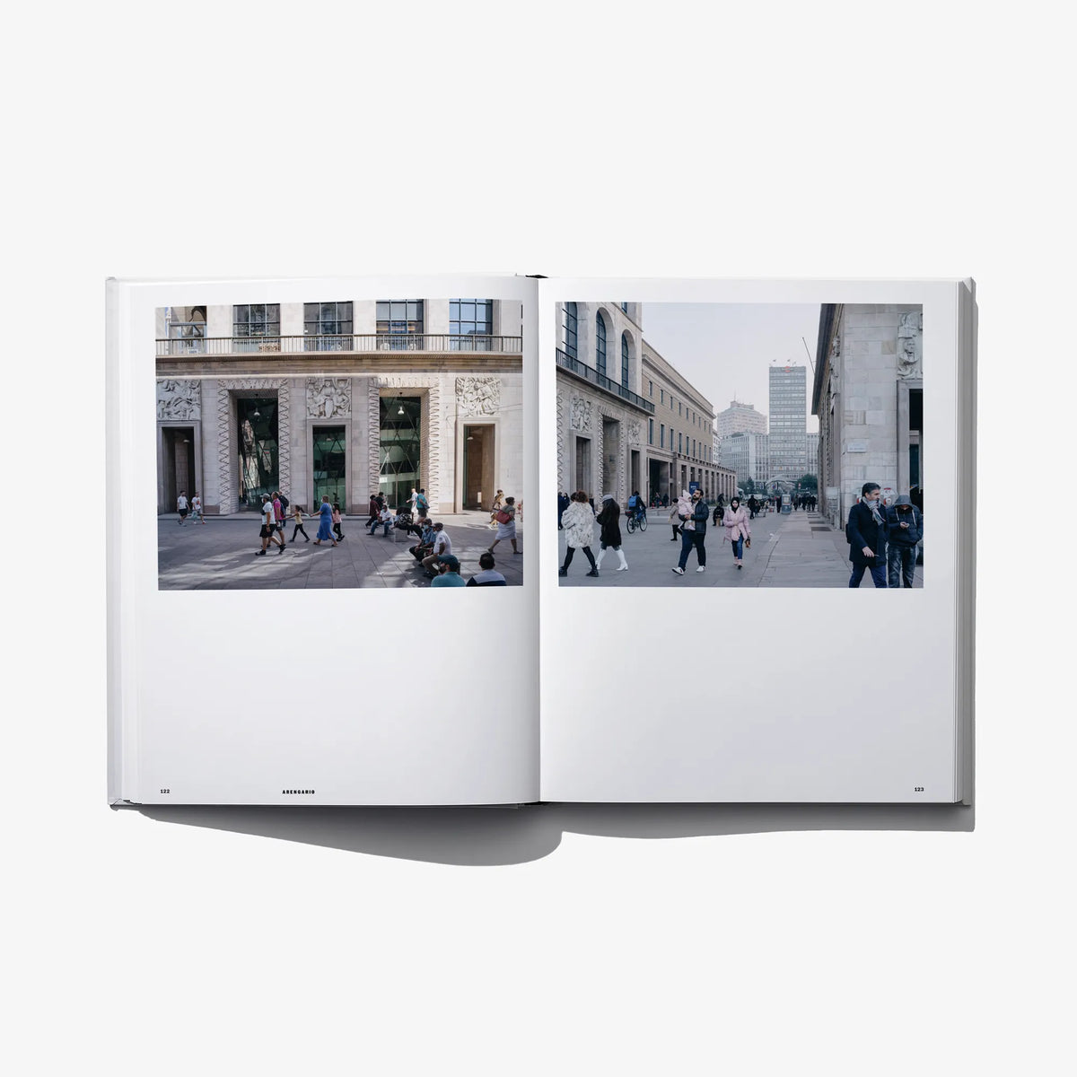 Open hardcover book with two color photos of people walking in a city street.