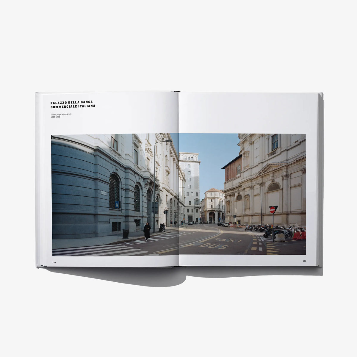 Open hardcover book showing a street view with historic facades on both pages.