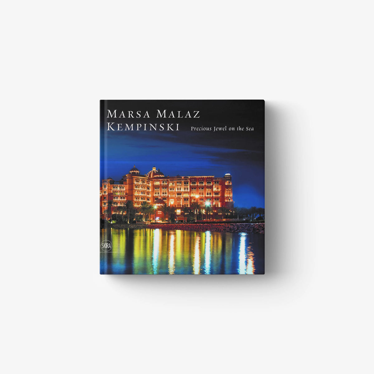 Hotel architecture book by Skira Arte with blue night sea cover and illuminated resort buildings