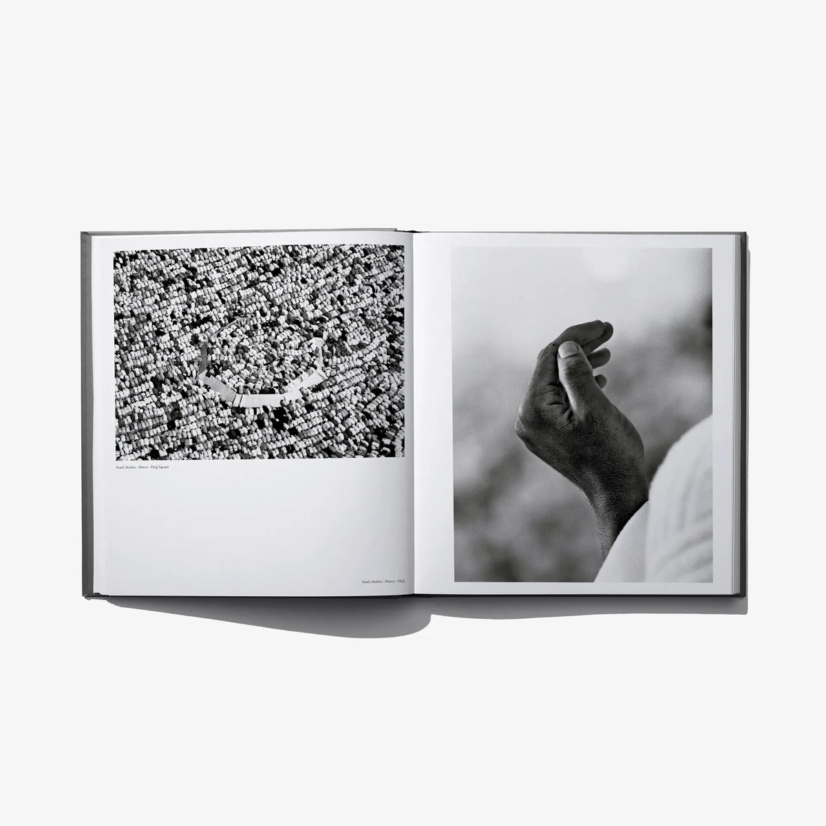 Open photo book spread with a patterned crowd image and a hand close-up, black-and-white