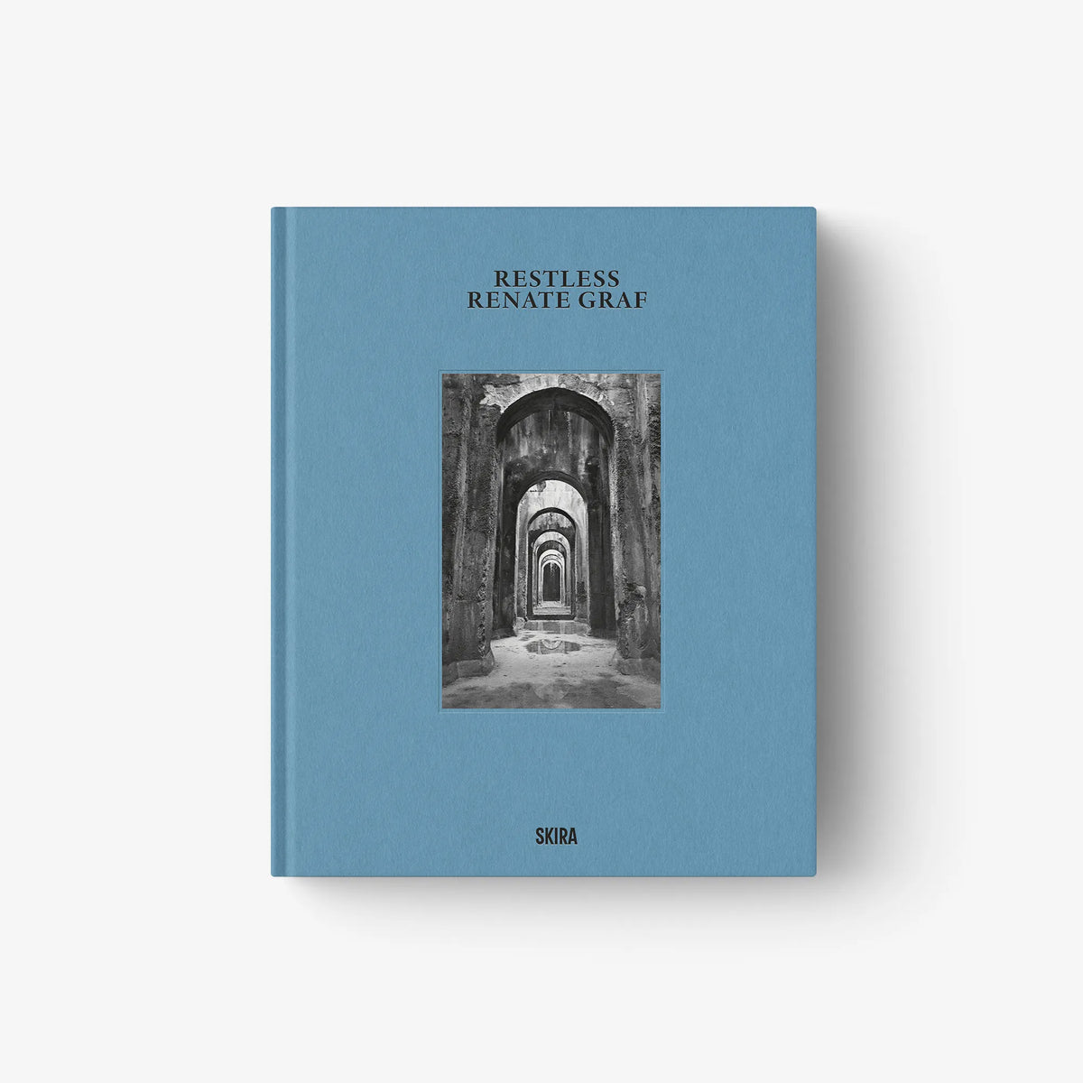 Blue hardcover art book with monochrome cathedral arch photo on front cover