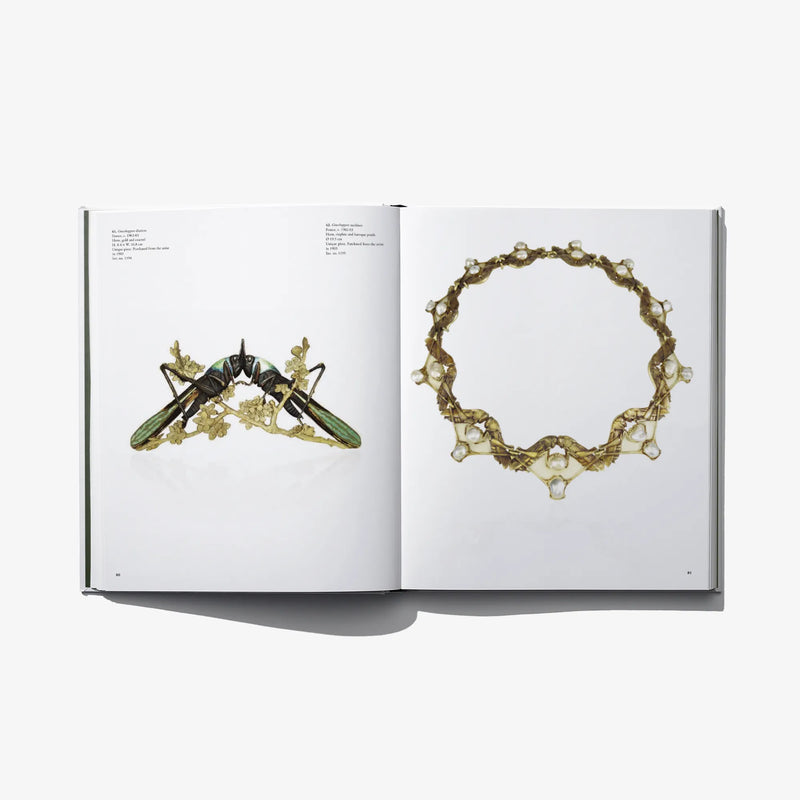Open art book showing gold jewelry designs: bracelet on right, necklace on left