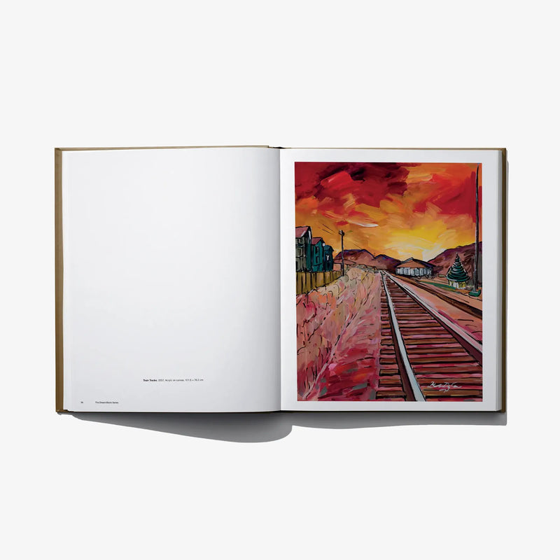 Hardcover photo book open to colorful train landscape artwork