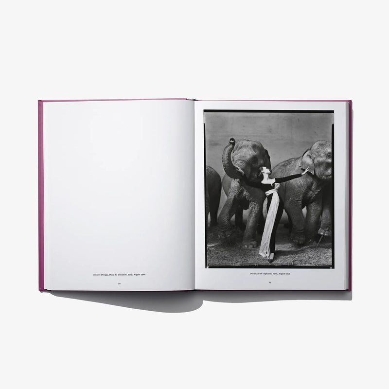 Open photo book spread with a grayscale image of posed figures holding reins