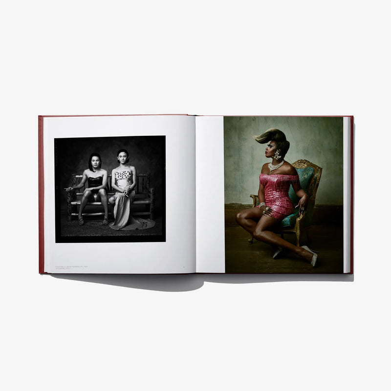 Opened hardcover book with two color portraits: two seated people; a woman in a red dress.