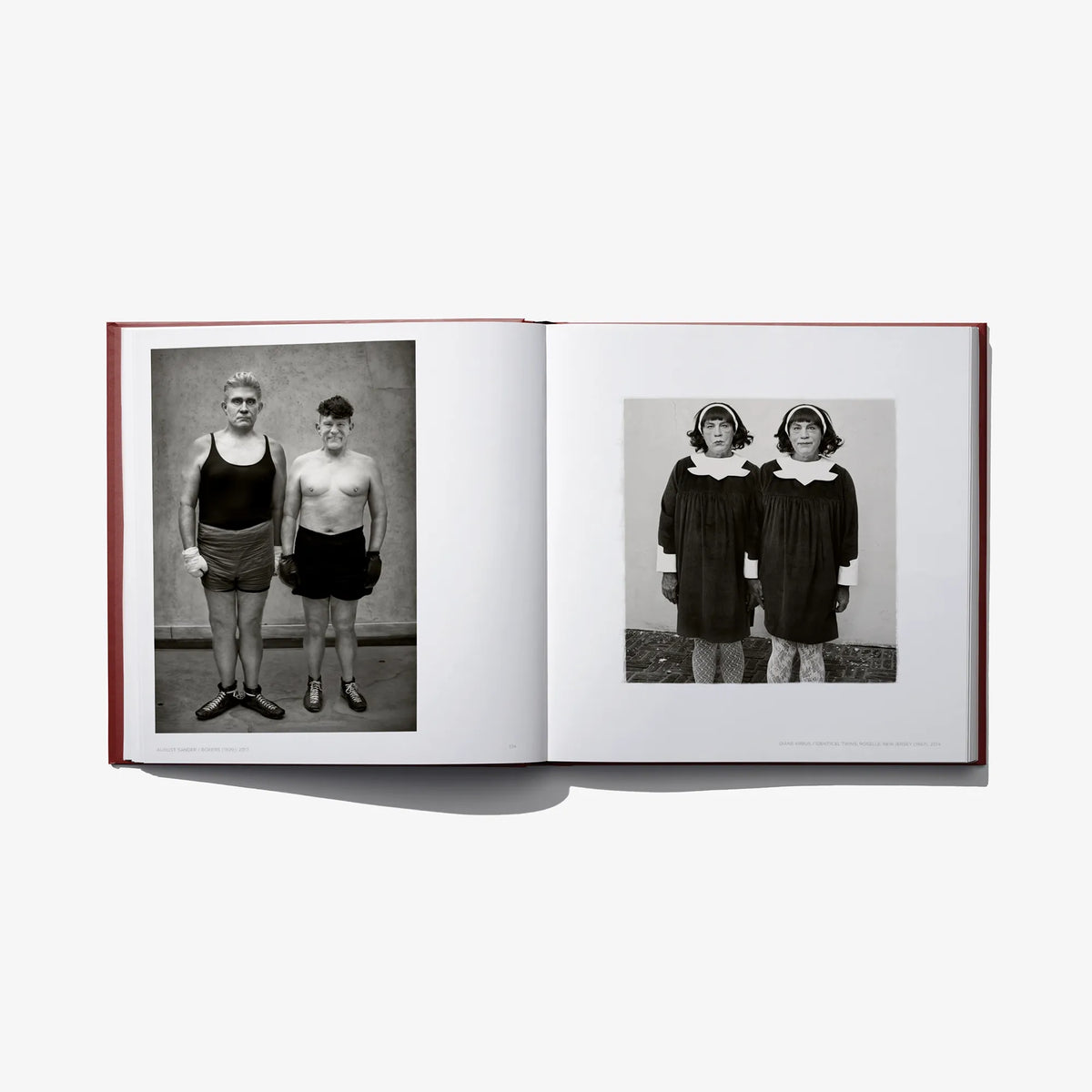 Opened hardcover book with two black-and-white photos: two people standing and posing.