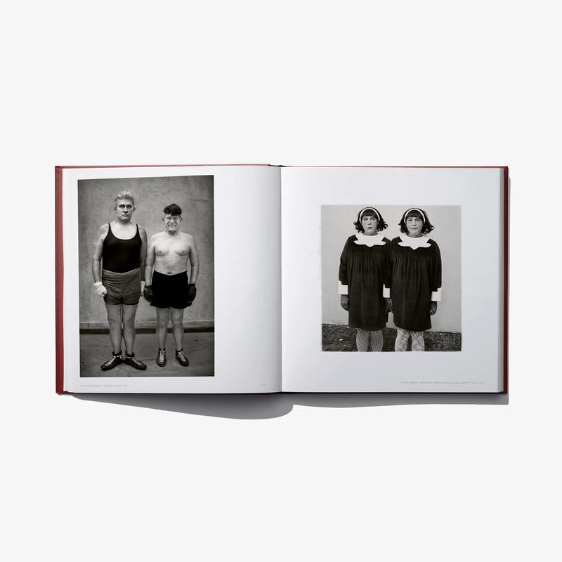 Opened hardcover book with two black-and-white photos: two people standing and posing.
