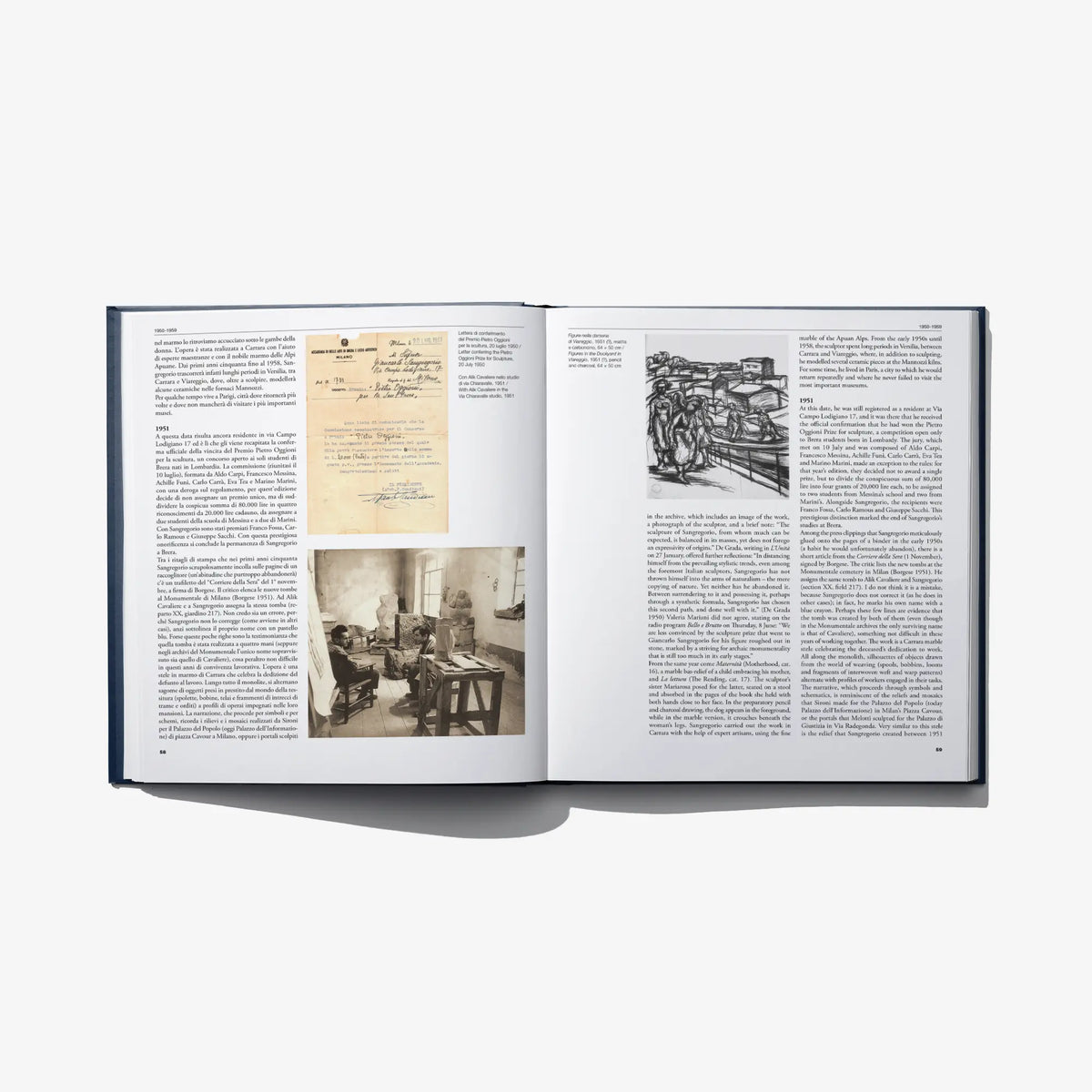 Open art catalog book with historical photos and handwritten notes pages