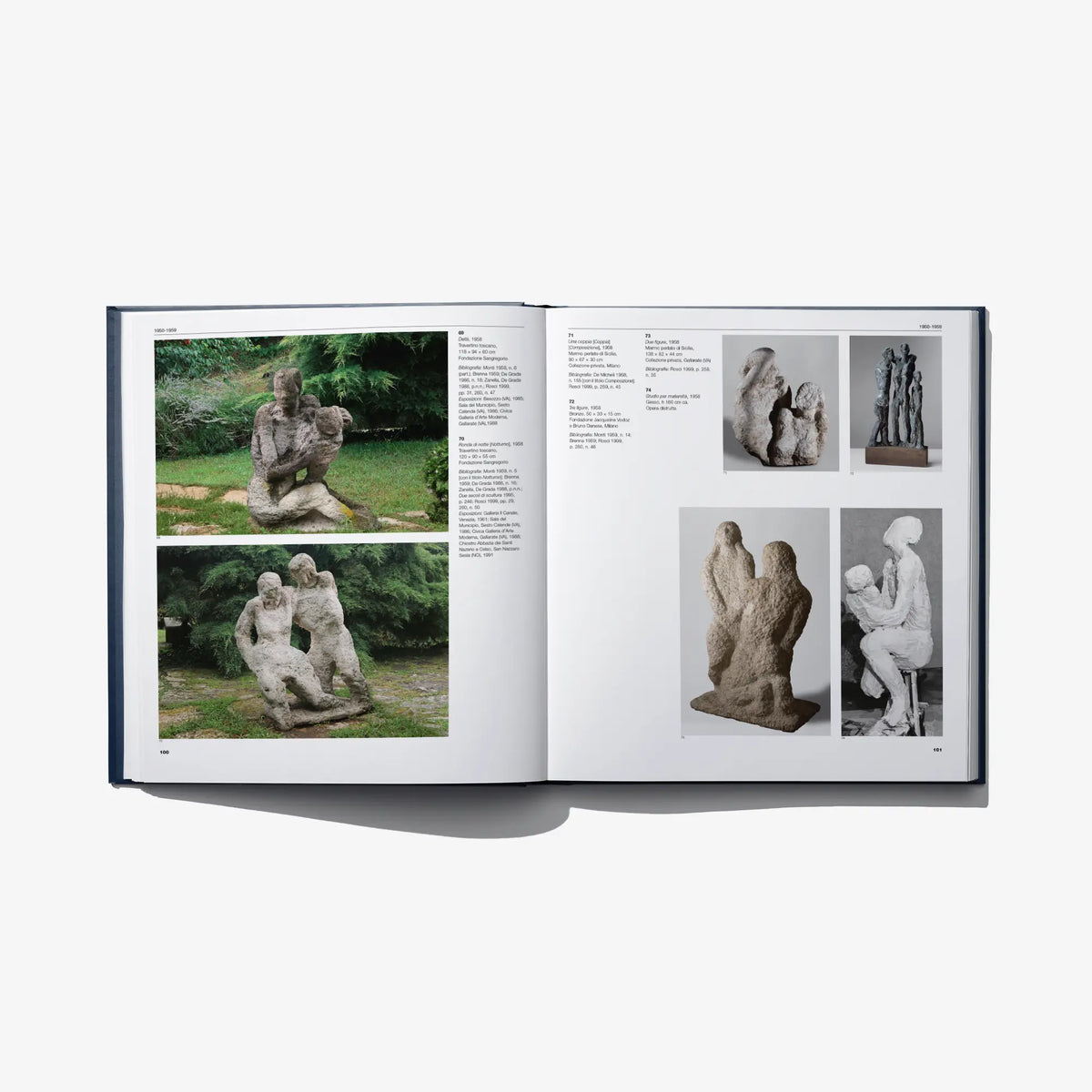 Open art catalog book with outdoor sculpture photos and side details