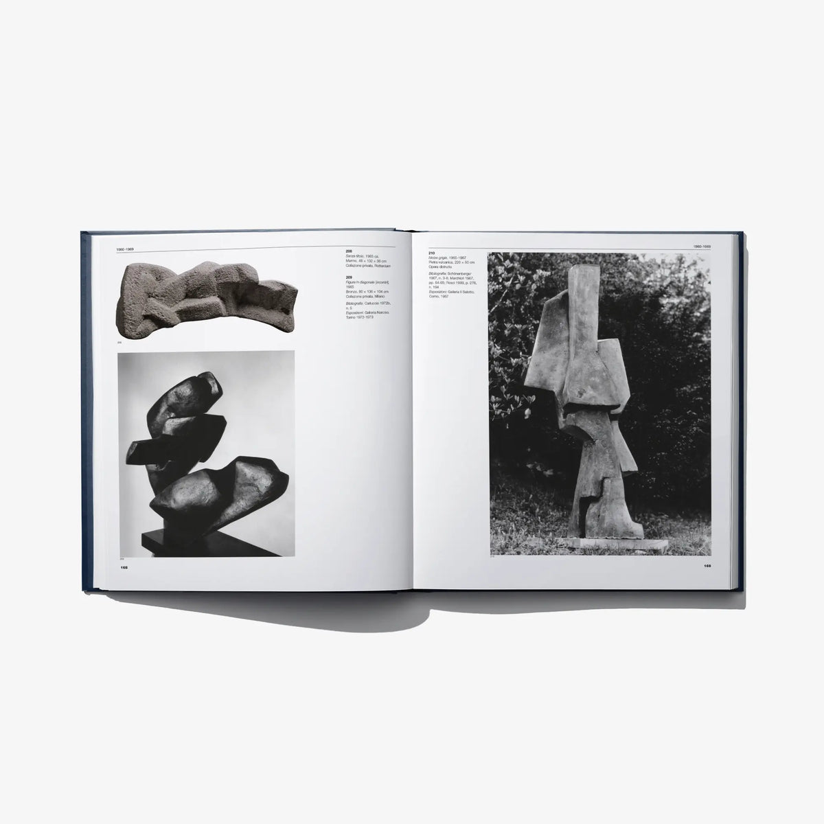 Open art catalog book with photos of sculptures on two pages