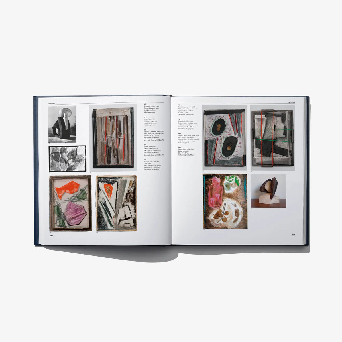 Open art catalog book showing mixed artwork images and framed pieces on pages