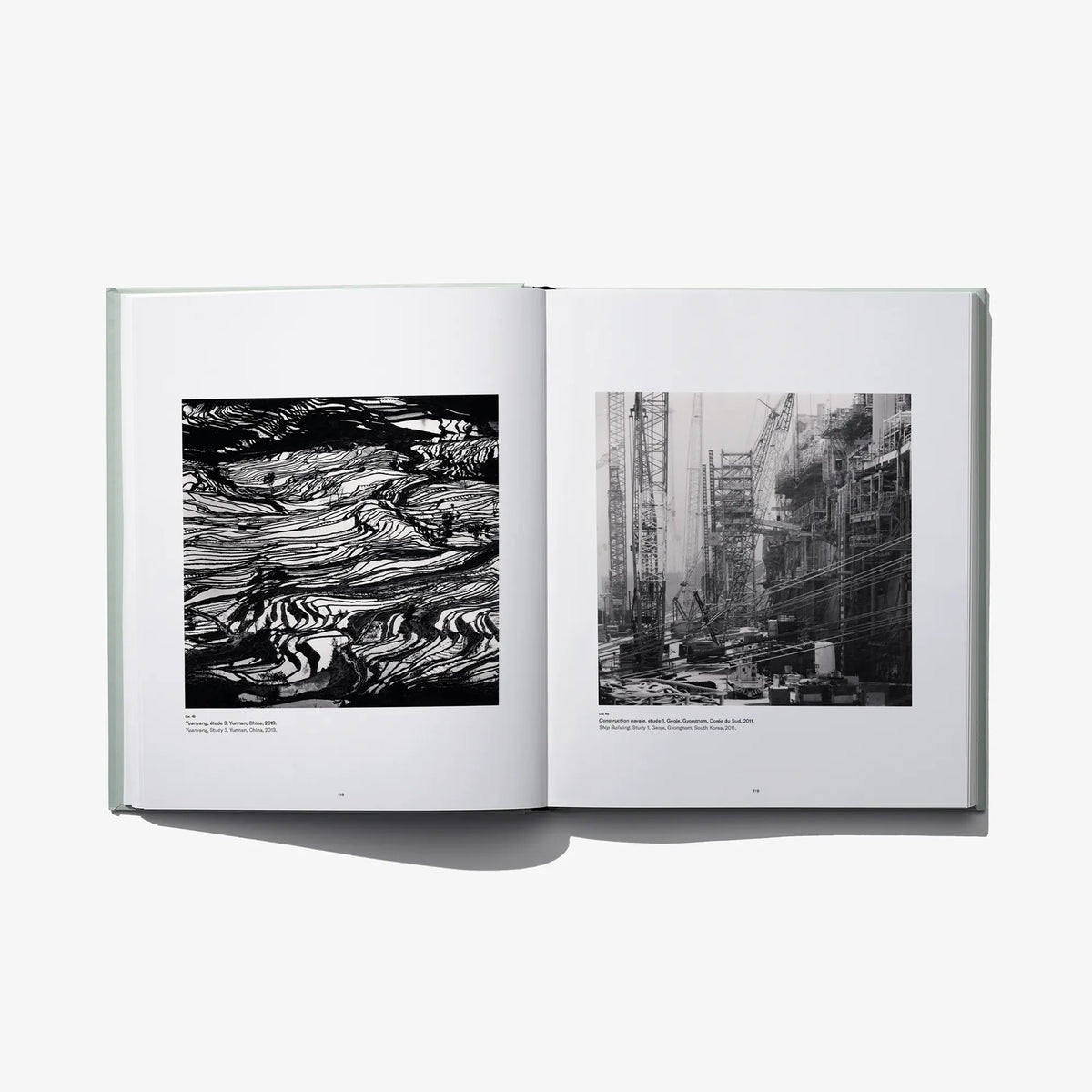 Open photo book spread with black-and-white abstract patterns and industrial buildings.