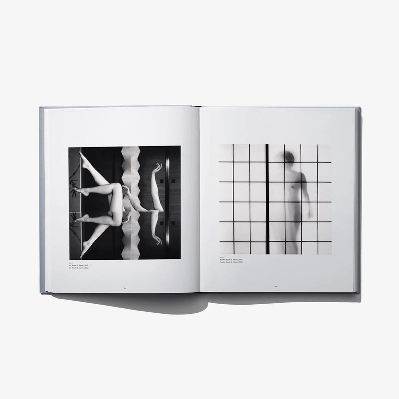 Open photo book spread with nude figure photo and grid-lined nude silhouette print.