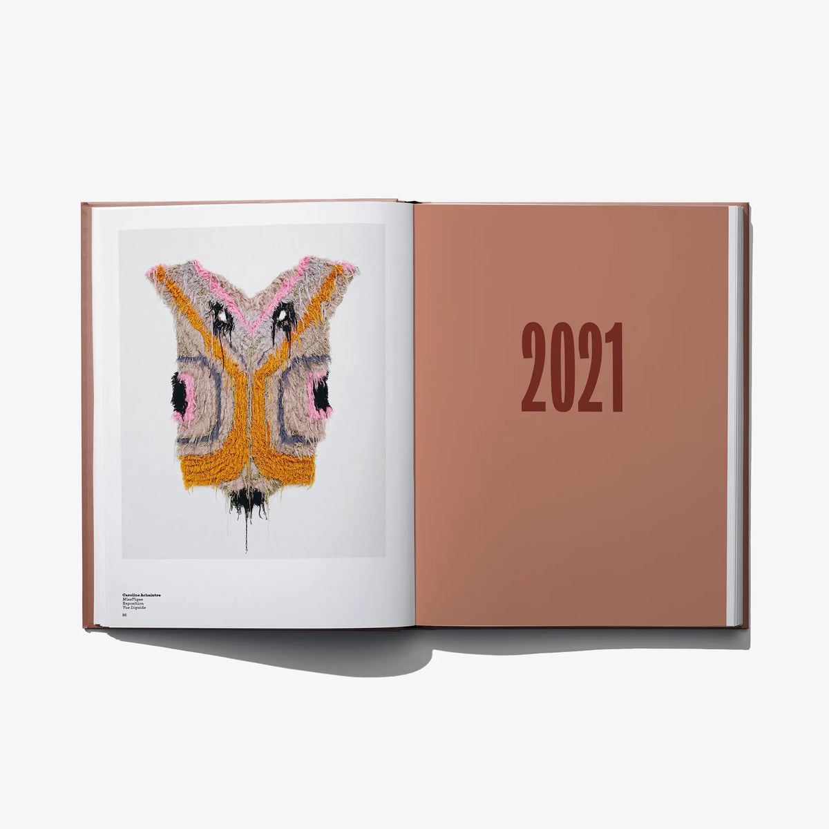 Open art book with a colorful beaded fabric artwork and a “2021” page