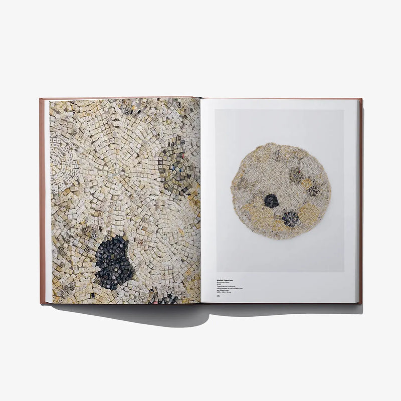 Open art book featuring a mosaic wall image and a round textured artwork