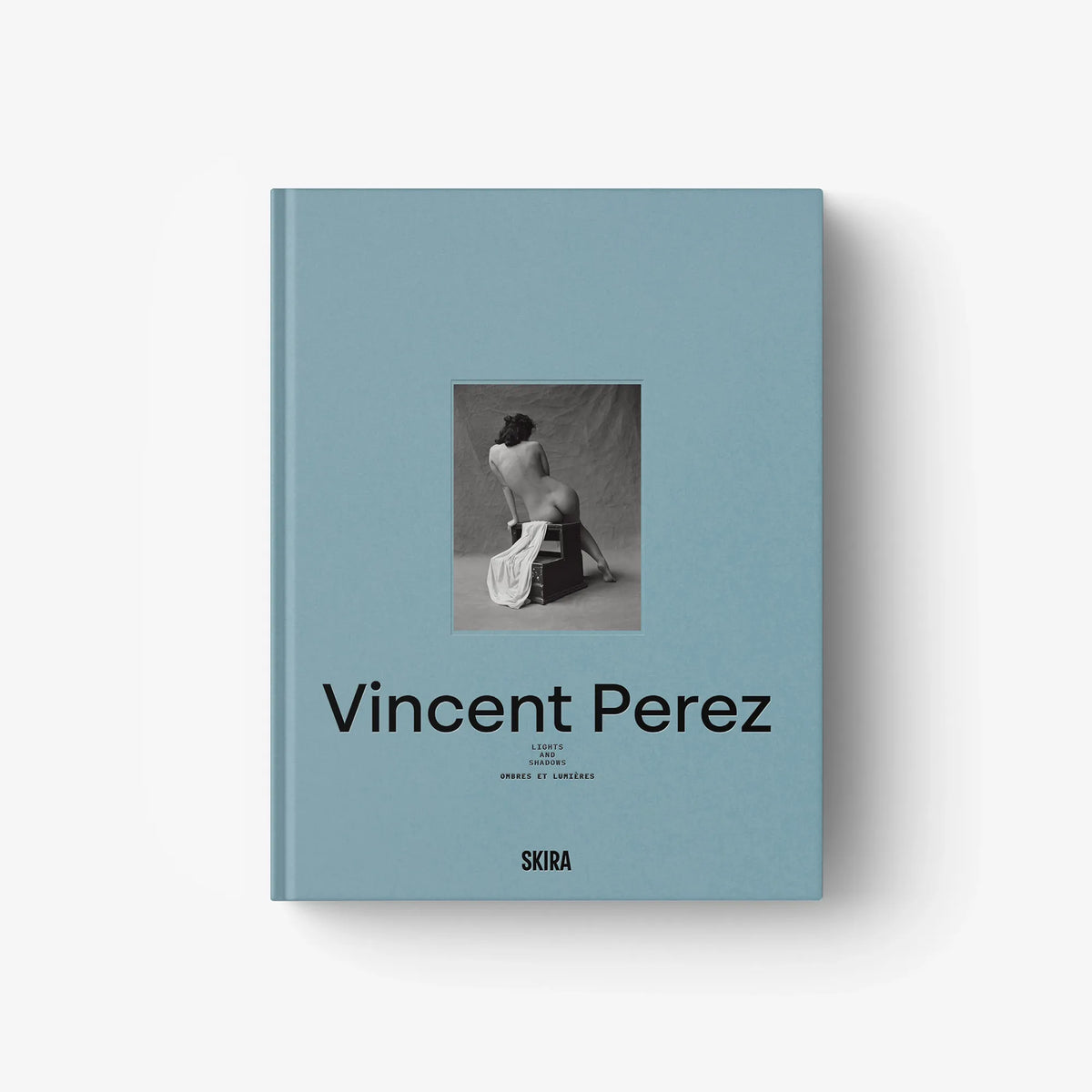 Light blue hardcover book with central photo and black title lettering