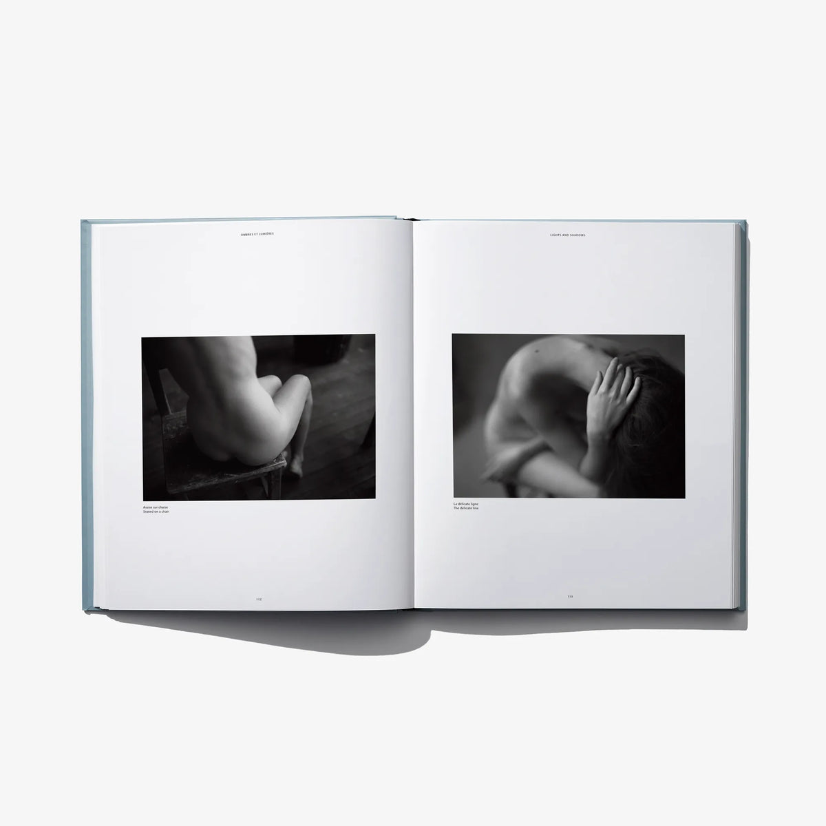 Open book spread with two black-and-white close-up photos of hands and torso