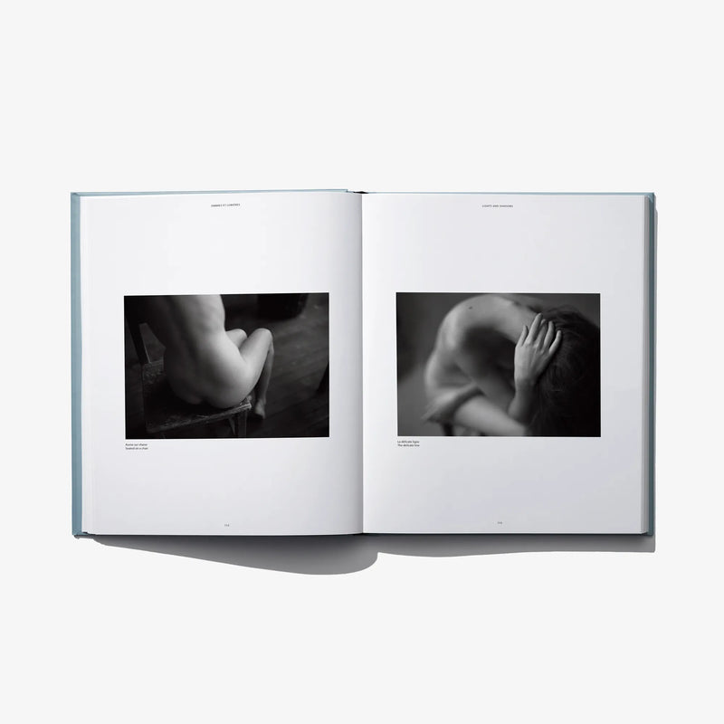 Open book spread with two black-and-white close-up photos of hands and torso