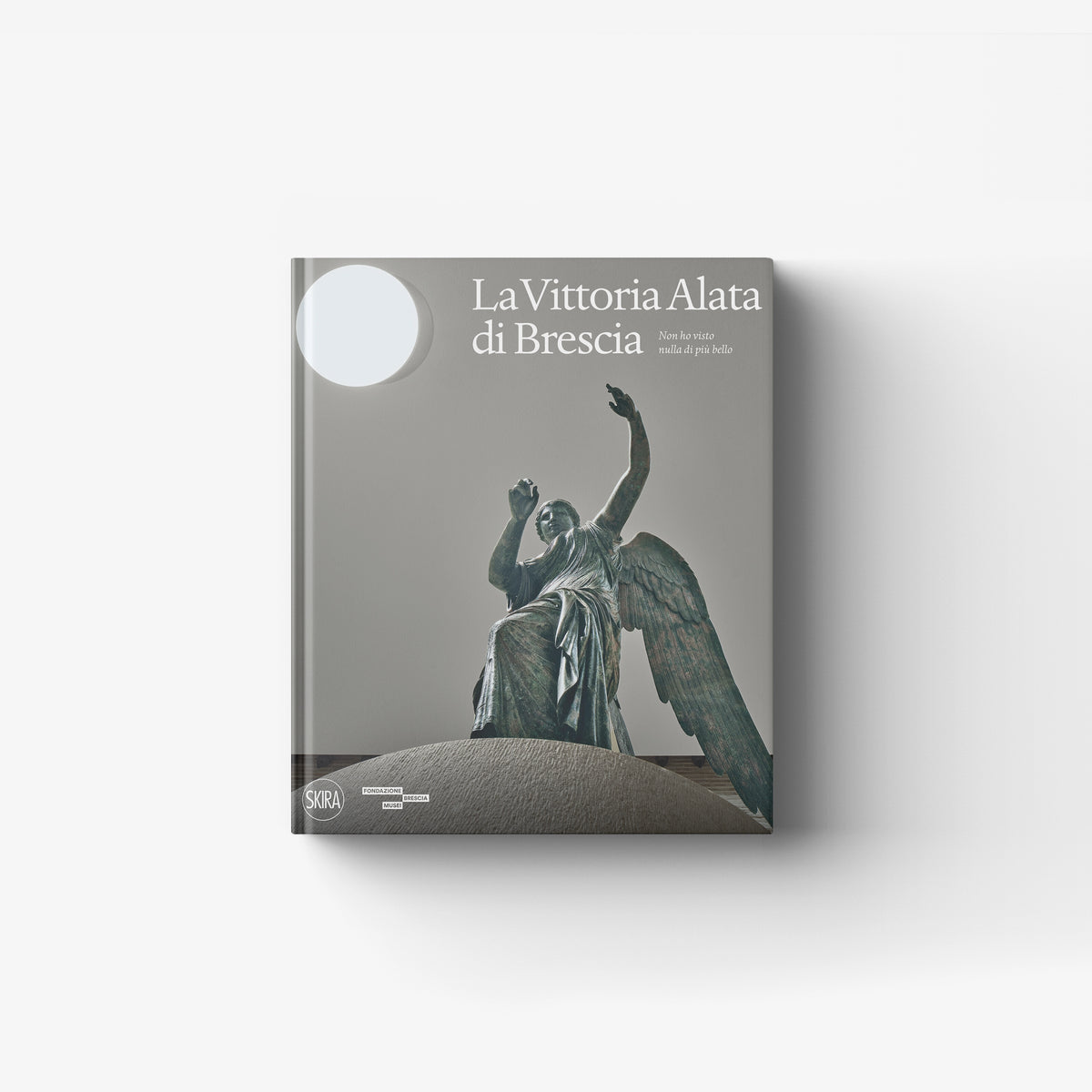 Art book La Vittoria Alata di Brescia by Skira Arte with bronze statue cover illustration and museum style setting
