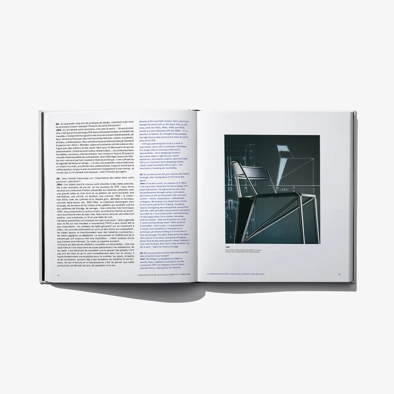 Open design book with printed text and photo of dark modern furniture and frames
