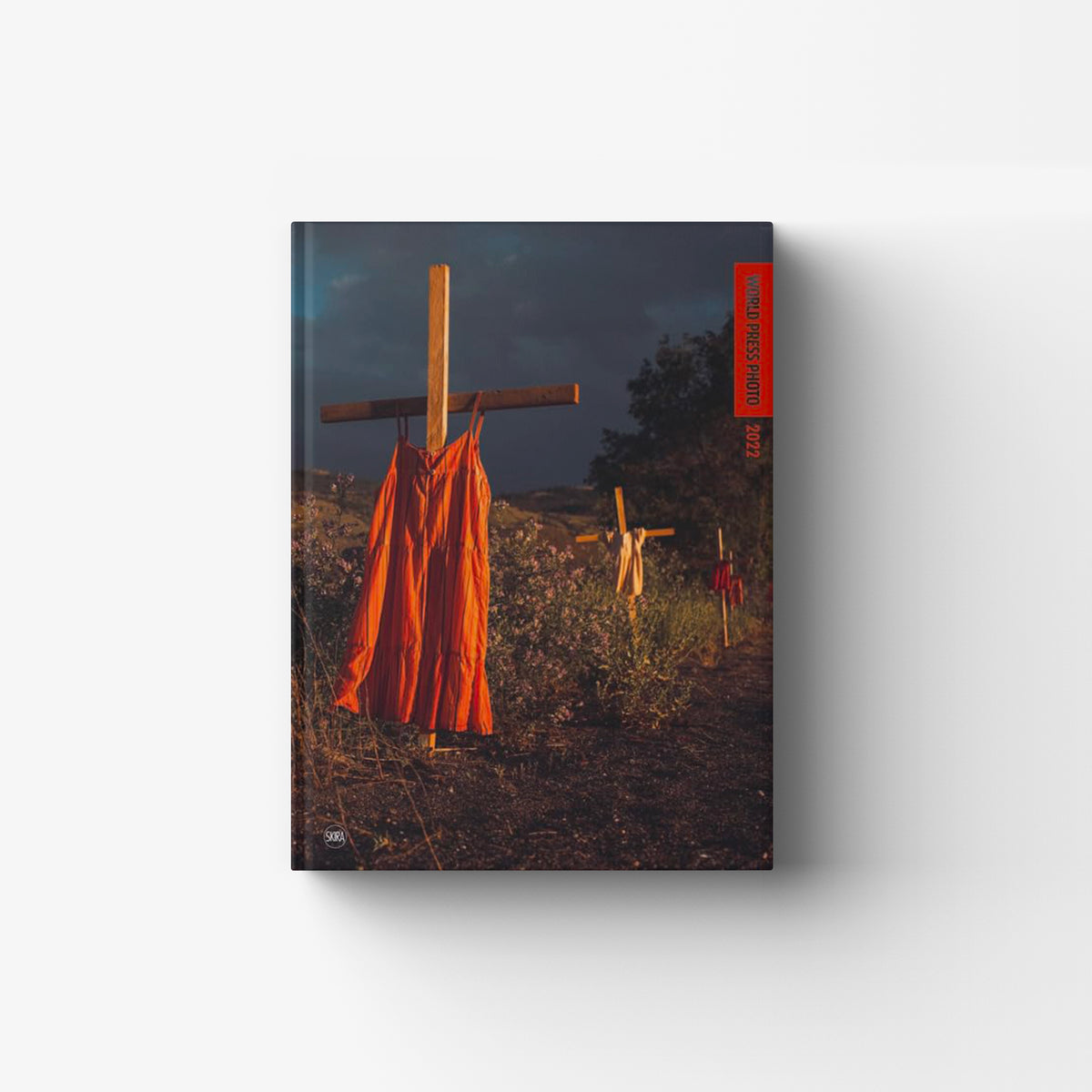 Photographic journalism book by Skira Arte with hardback cover, featuring a dark field scene and orange flags