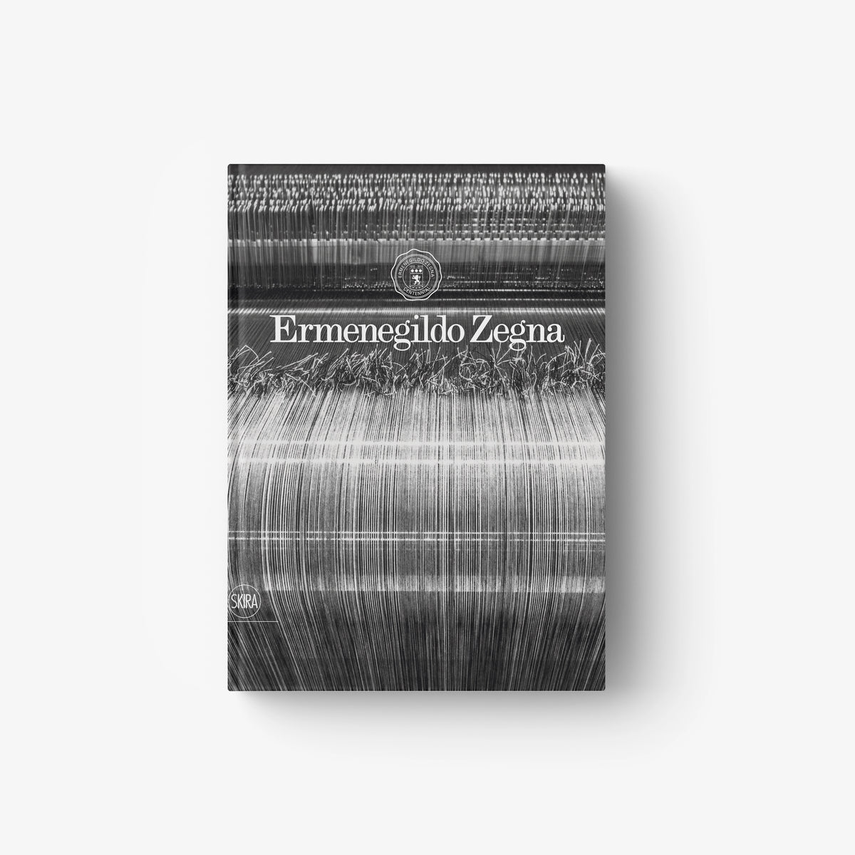 Hardcover book with Ermenegildo Zegna title on gray striped abstract cover